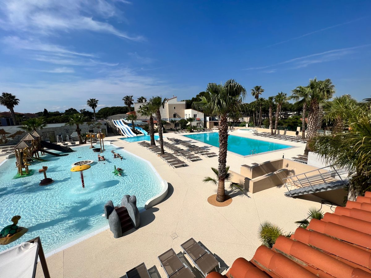 Complejo residencial con piscinas y zona infantil con pavimento Resineo